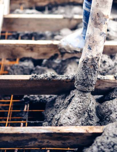 construction worker pouring cement on stairs, creating sidewalks and stairs on new building site